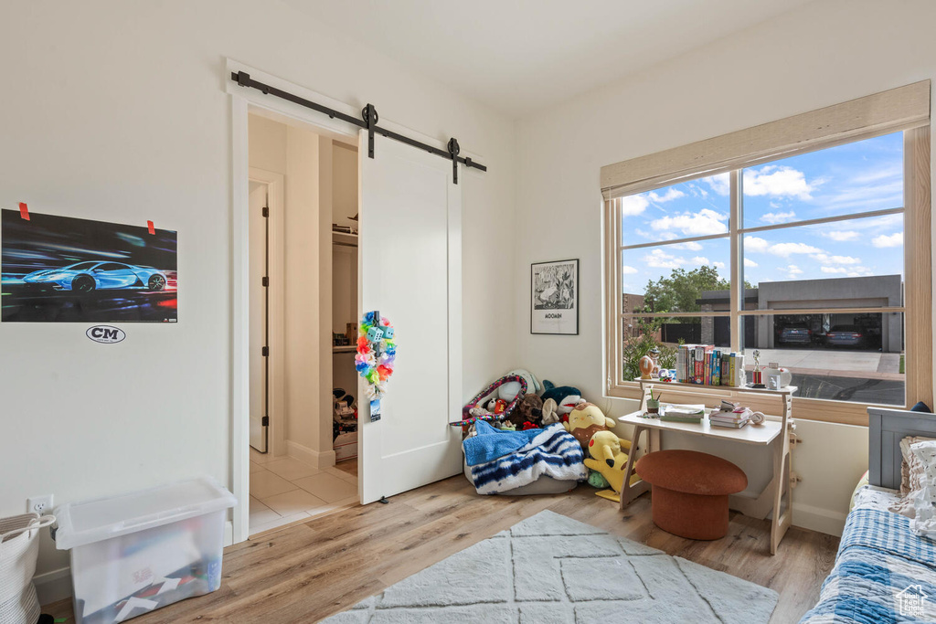 Living area featuring a barn door and wood finished floors