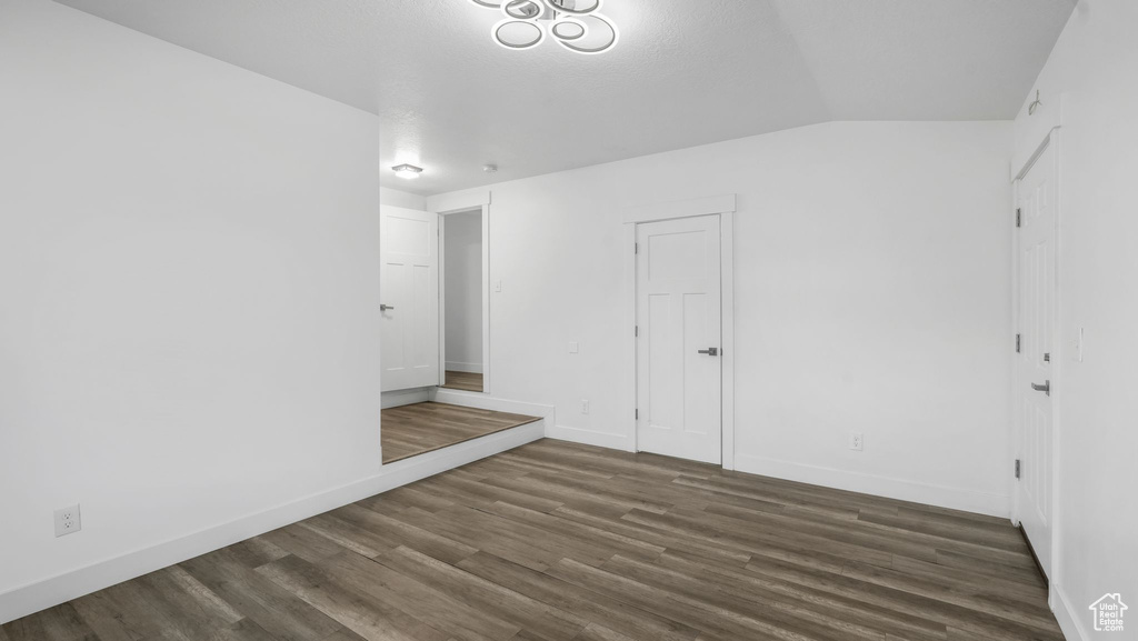 Empty room featuring wood finished floors and lofted ceiling