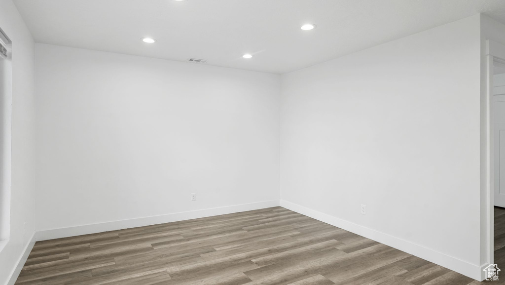 Unfurnished room with wood finished floors and recessed lighting