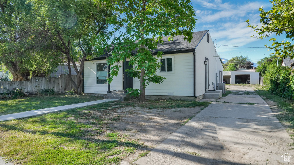 View of front of property with concrete driveway, entry steps, and a shingled roof