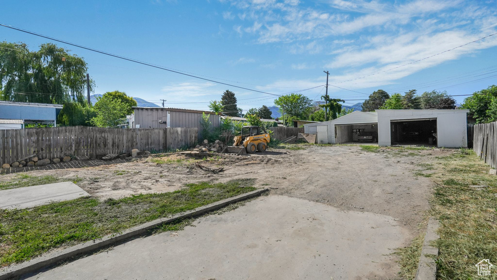 View of yard featuring a detached garage and an outbuilding