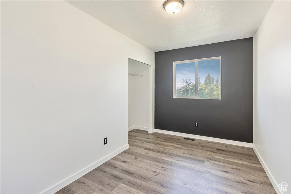 Spare room featuring light wood-type flooring and baseboards