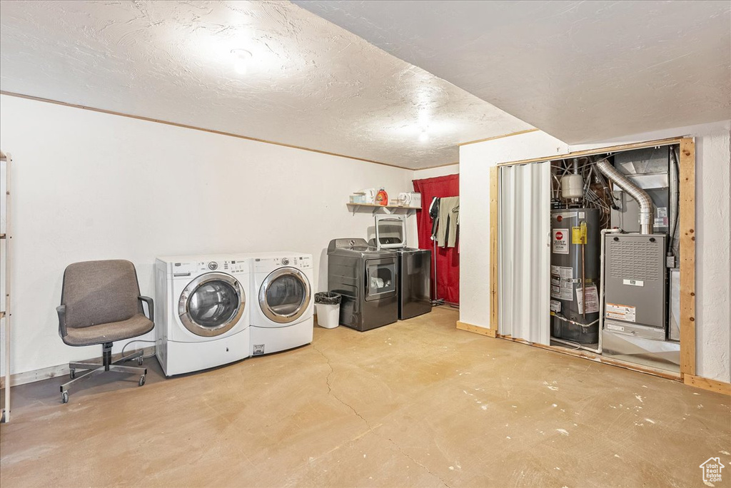 Laundry room with water heater, washer and clothes dryer, and heating unit