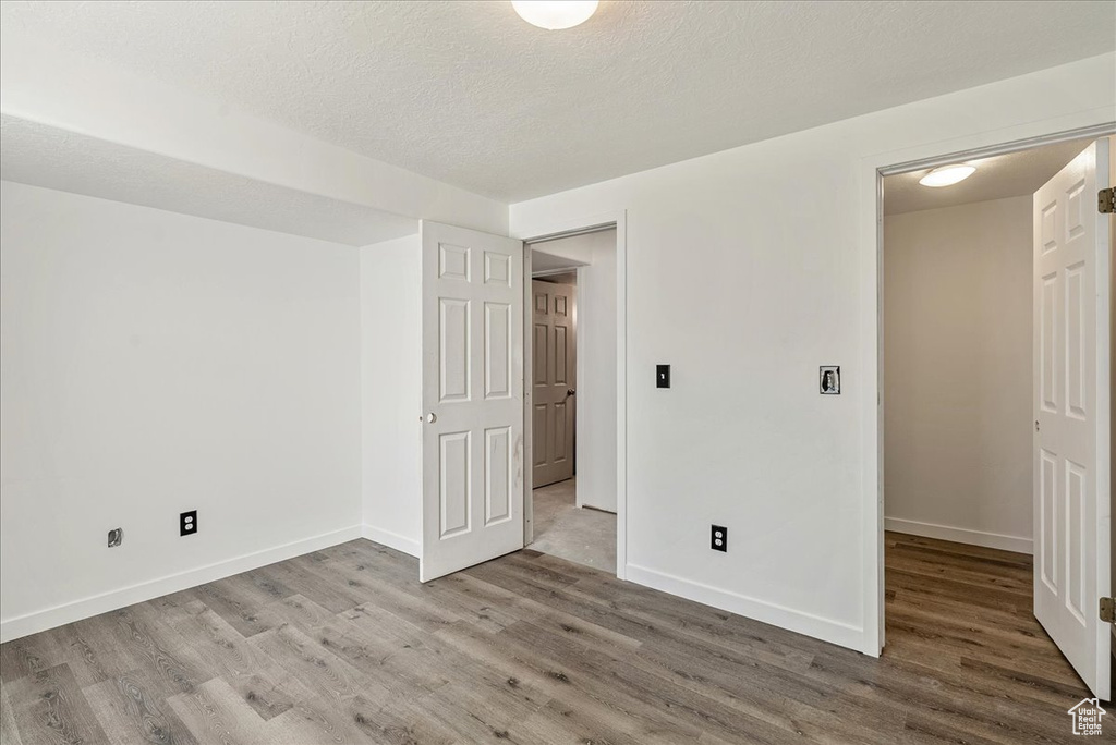 Unfurnished bedroom featuring wood finished floors and a textured ceiling