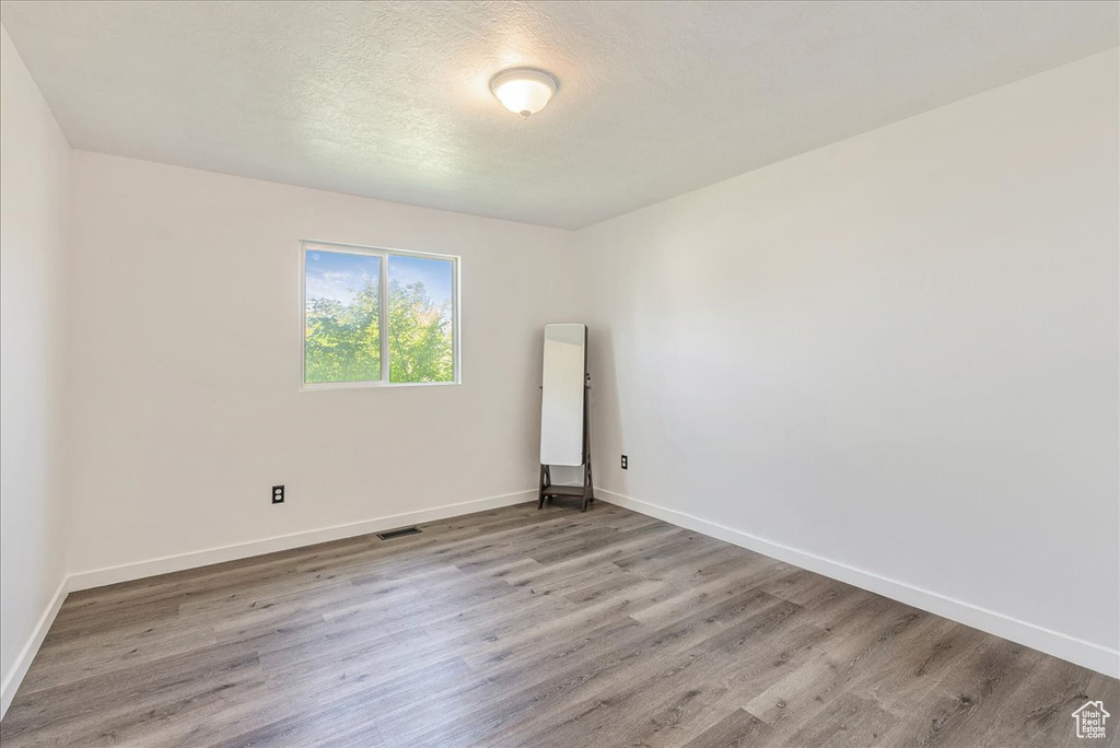 Empty room with light wood-style flooring and baseboards