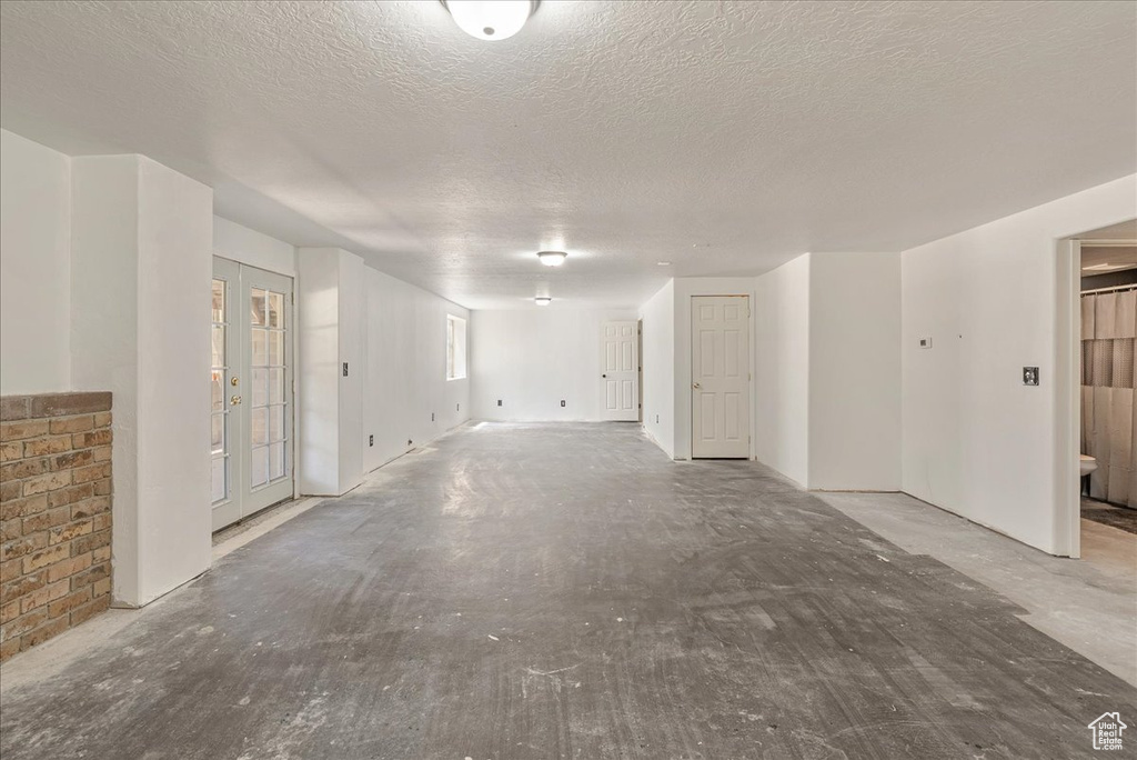 Empty room featuring a textured ceiling and french doors