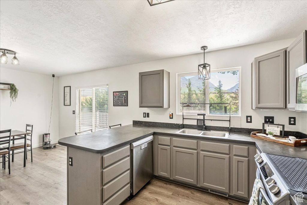 Kitchen featuring appliances with stainless steel finishes, gray cabinets, dark countertops, and a textured ceiling