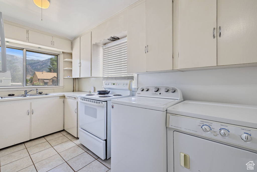 Laundry area featuring washing machine and clothes dryer and light tile patterned flooring
