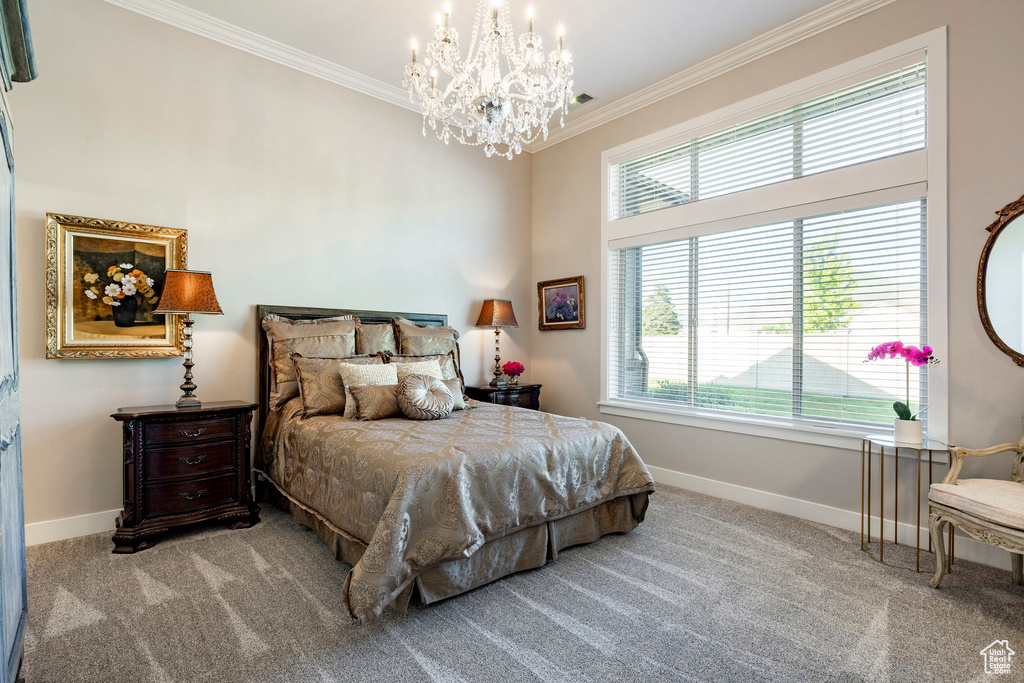 Carpeted bedroom with ornamental molding, a chandelier, and multiple windows