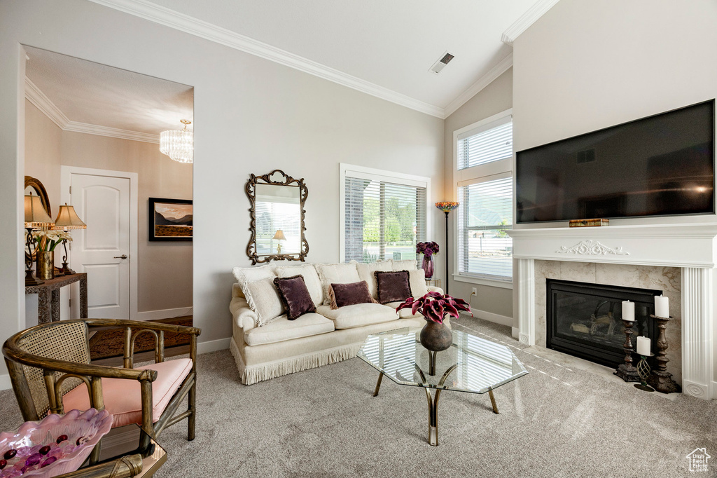 Living area with carpet, a high end fireplace, ornamental molding, a chandelier, and high vaulted ceiling