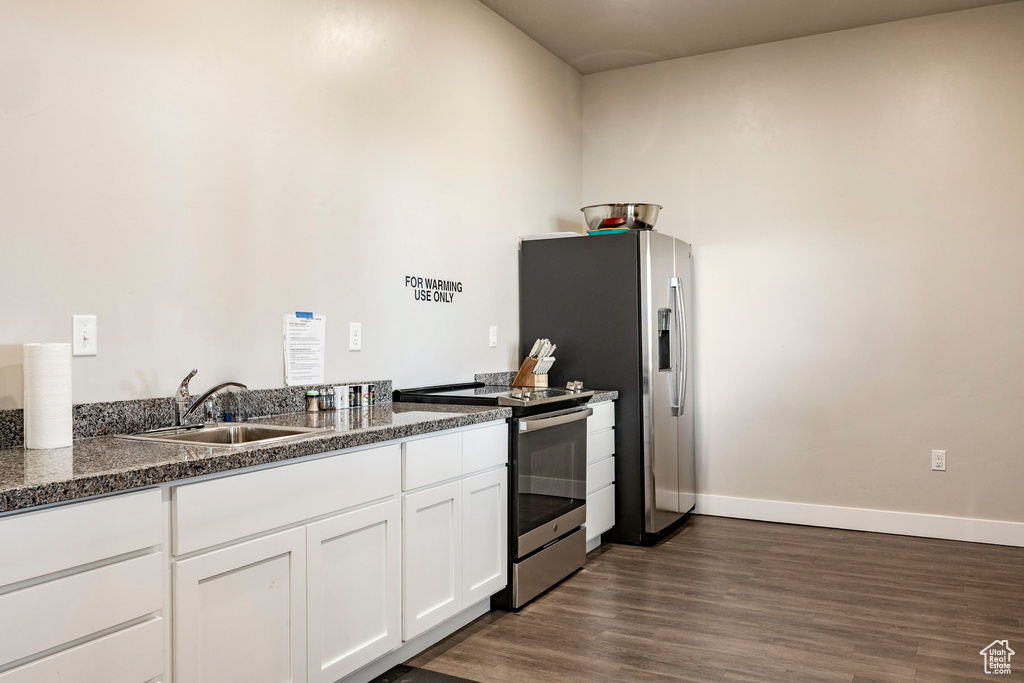 Kitchen featuring appliances with stainless steel finishes, white cabinetry, and dark wood finished floors