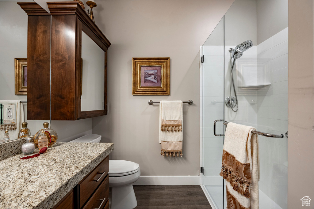 Full bathroom with vanity, a stall shower, and wood finished floors