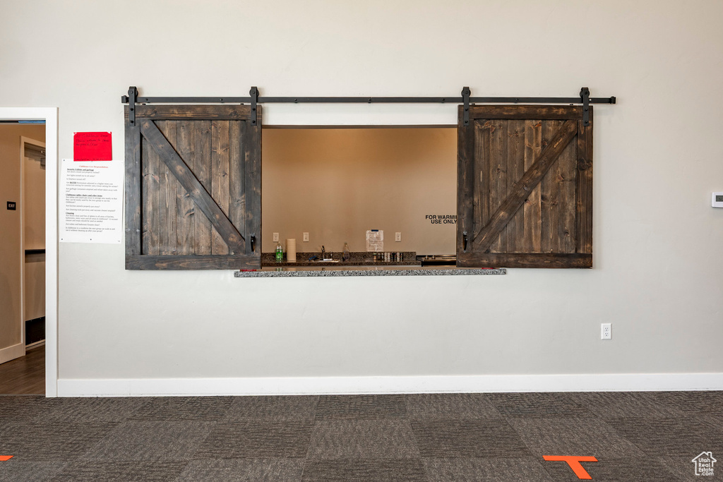 Detailed view of a barn door, carpet flooring, and a gate