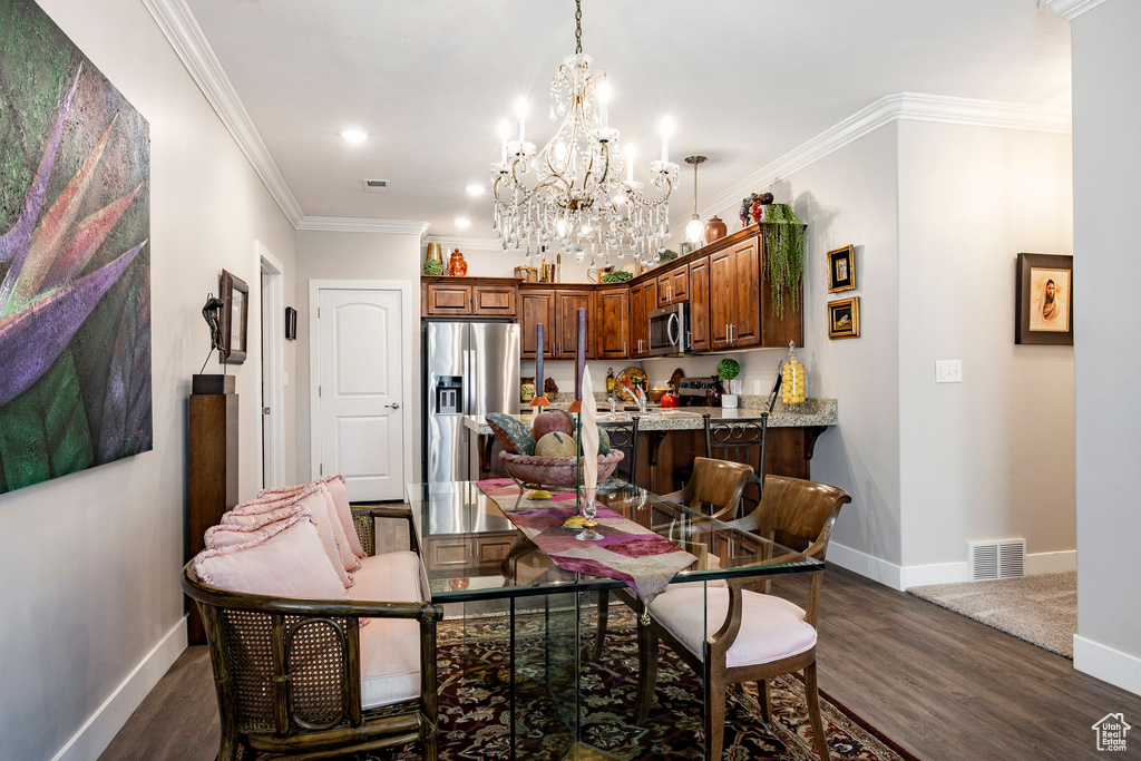 Dining space featuring dark wood-style floors, a chandelier, crown molding, and recessed lighting