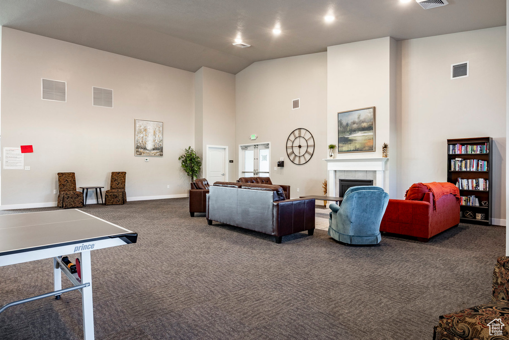 Game room featuring high vaulted ceiling, dark carpet, and a fireplace