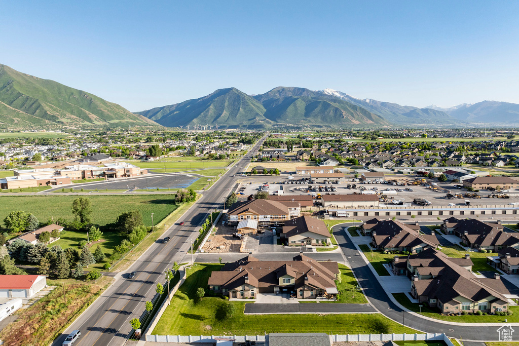 Aerial view of property and surrounding area featuring nearby suburban area and a mountainous background
