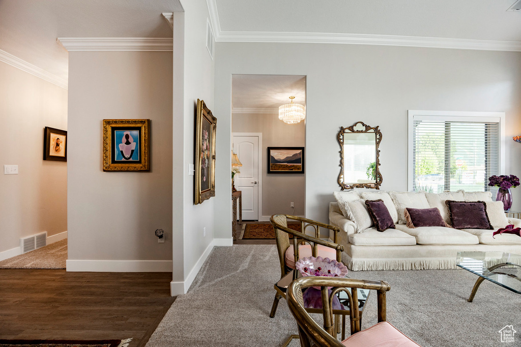 Living area with ornamental molding and wood finished floors