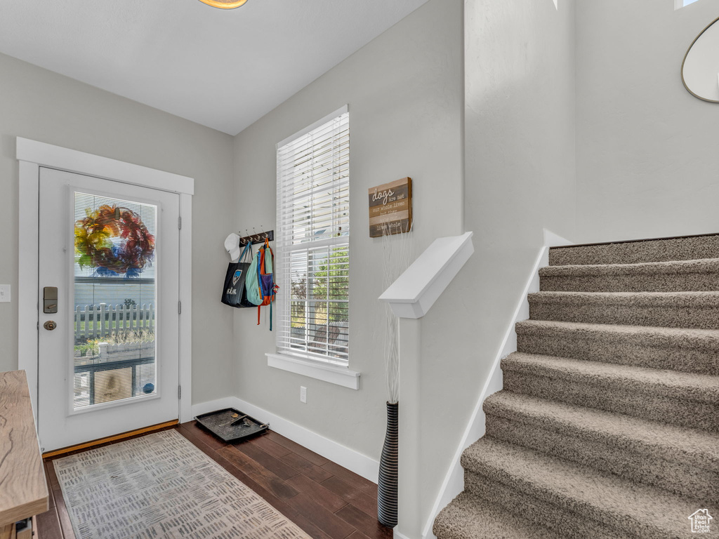 Entryway with dark wood-type flooring and stairway