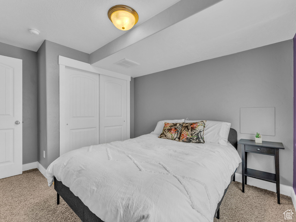 Bedroom featuring light carpet and a closet