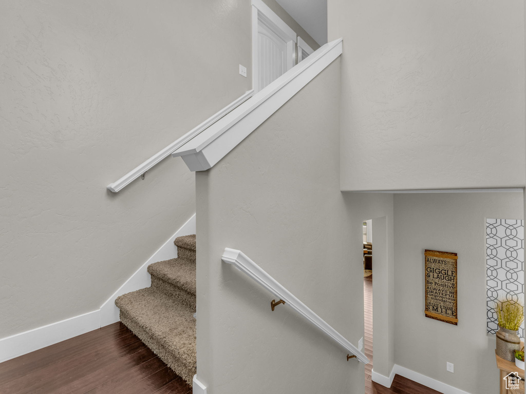 Stairway with wood finished floors and baseboards
