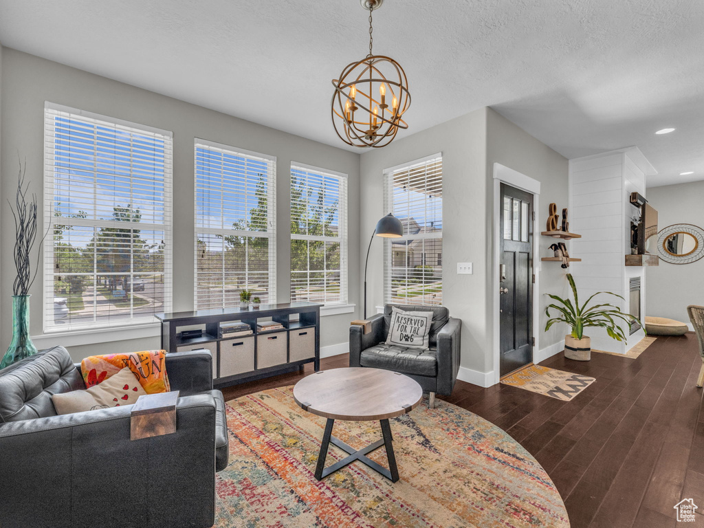 Living room with a chandelier, wood finished floors, and recessed lighting
