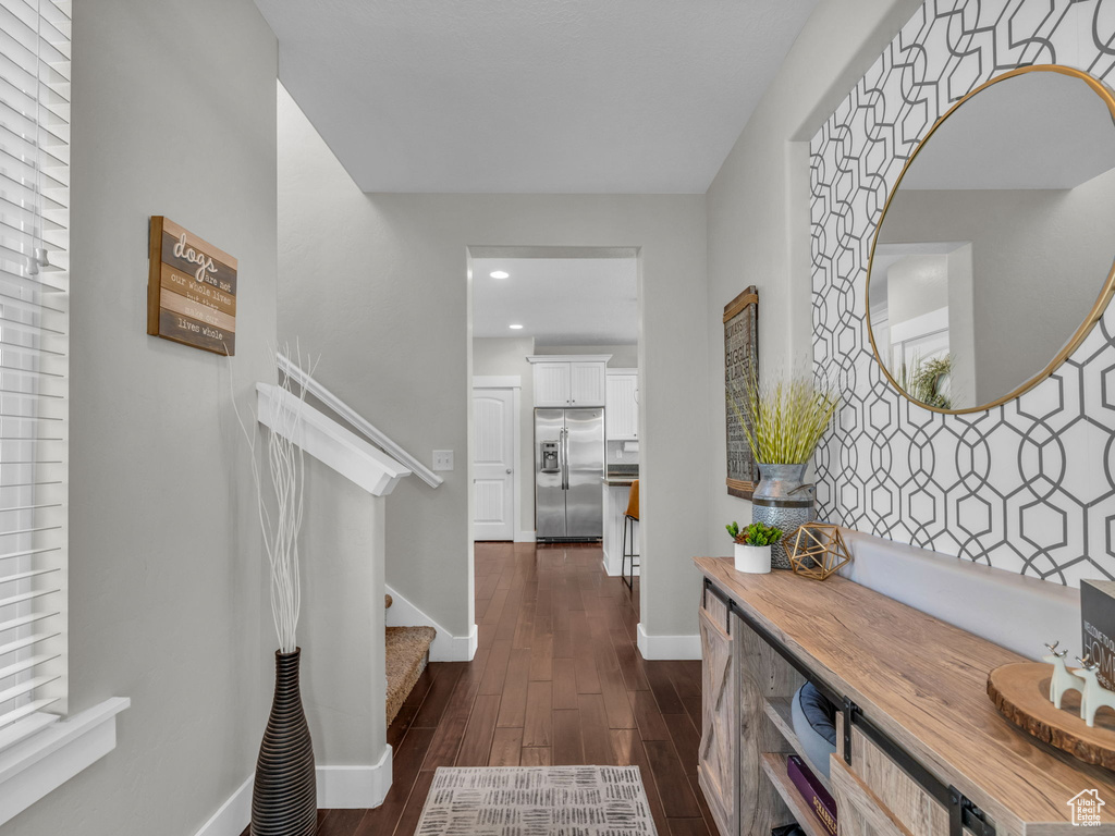 Hall with dark wood-type flooring, stairs, and recessed lighting