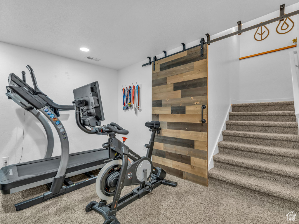 Exercise room featuring a barn door and recessed lighting