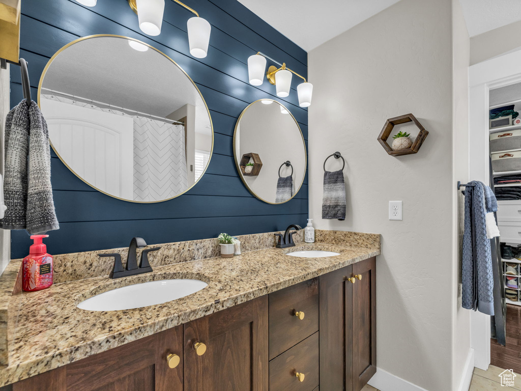 Bathroom featuring double vanity and a closet