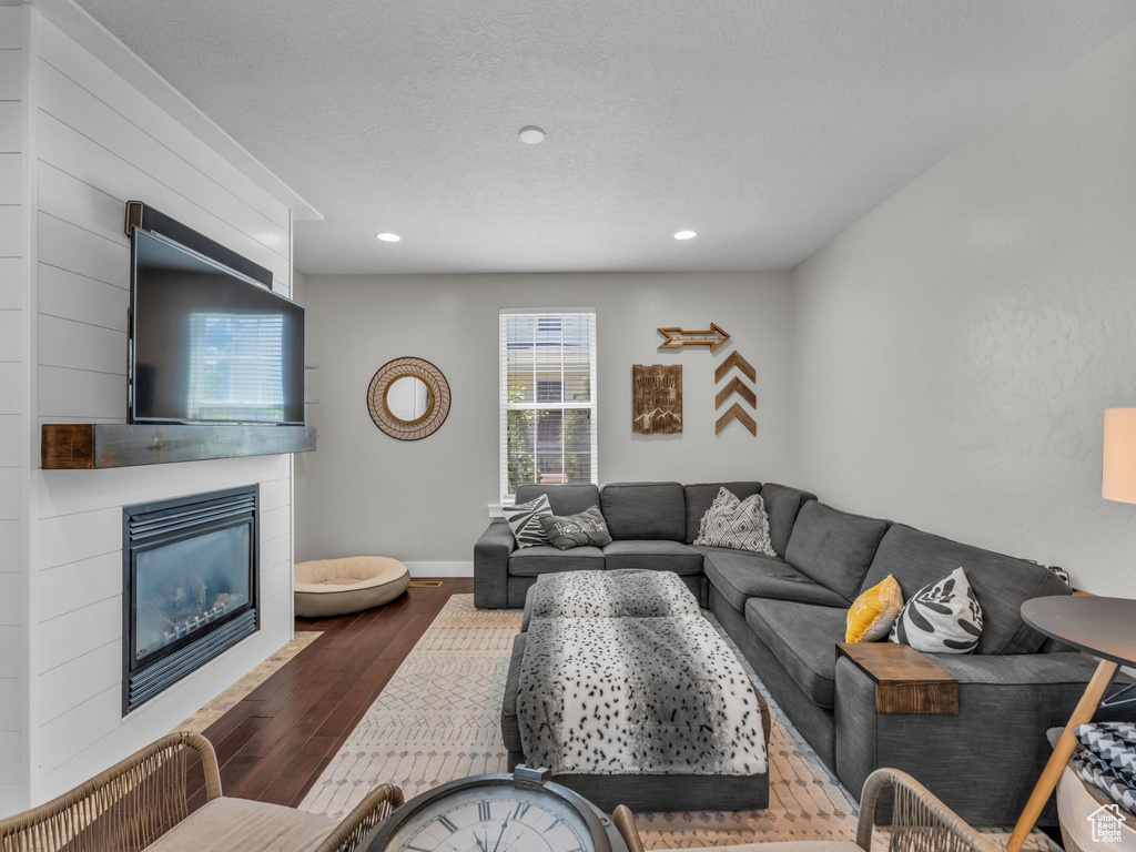 Living area featuring wood finished floors, a tile fireplace, and recessed lighting