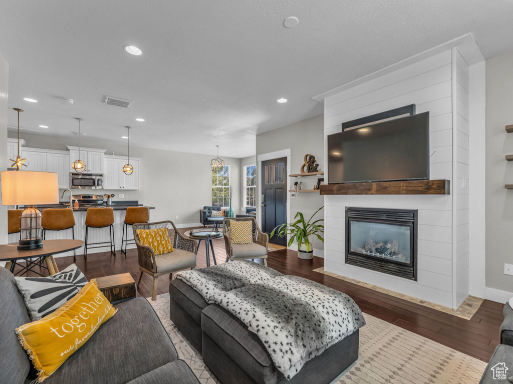 Living room featuring wood finished floors, a fireplace, and recessed lighting