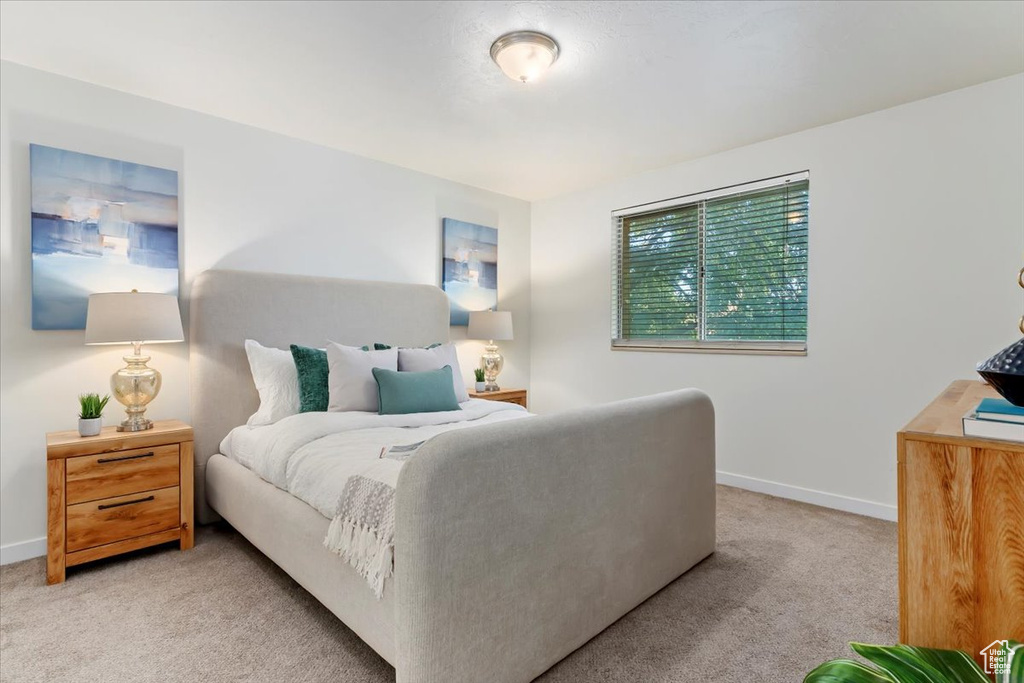 Bedroom featuring light carpet and baseboards