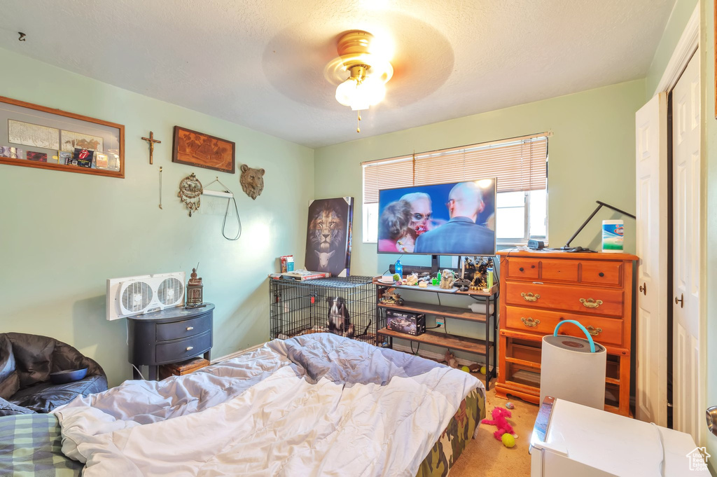 Carpeted bedroom featuring a ceiling fan