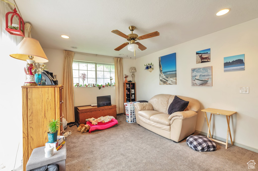 Carpeted living room with ceiling fan and recessed lighting