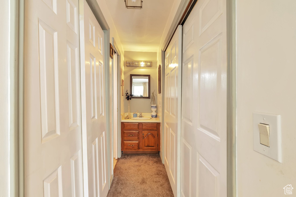 Hallway with light carpet and a sink