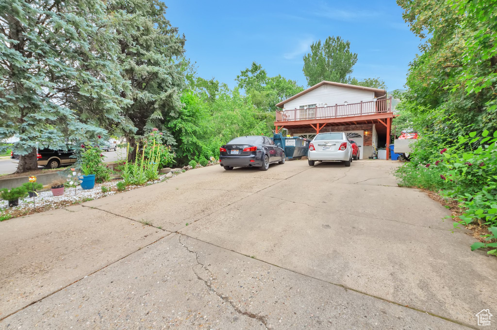 View of parking with driveway and a carport
