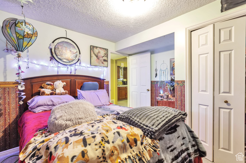 Bedroom with a textured ceiling and a closet