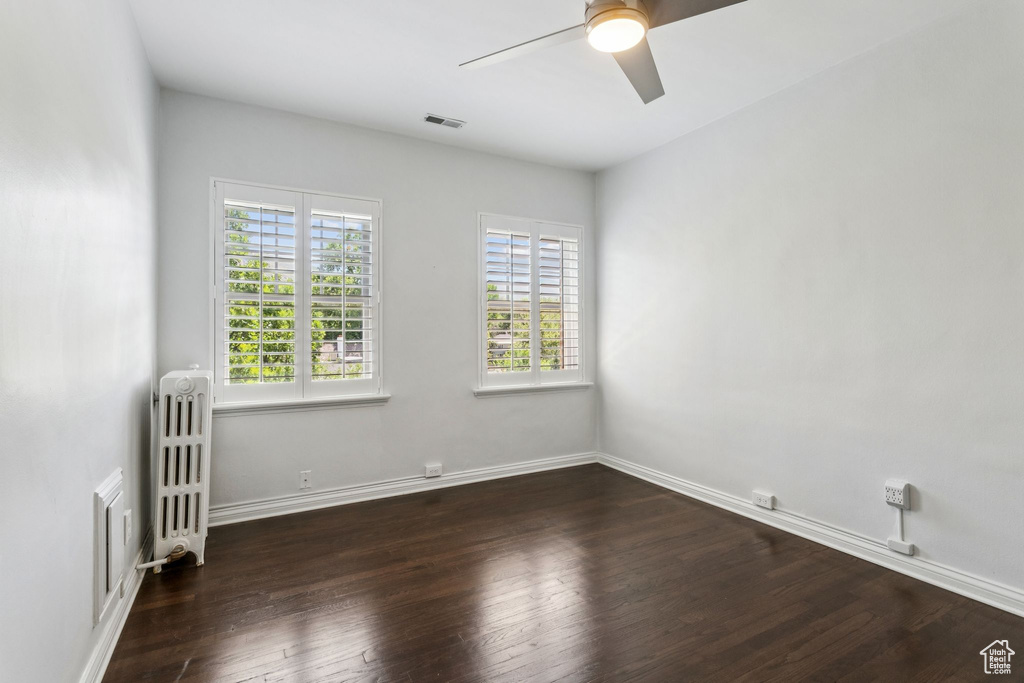 Spare room featuring radiator, ceiling fan, and hardwood / wood-style floors