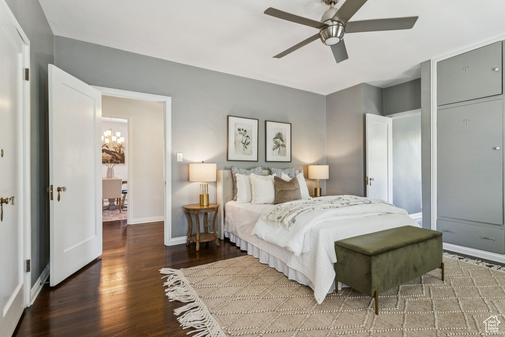 Bedroom featuring wood finished floors, a chandelier, and ceiling fan