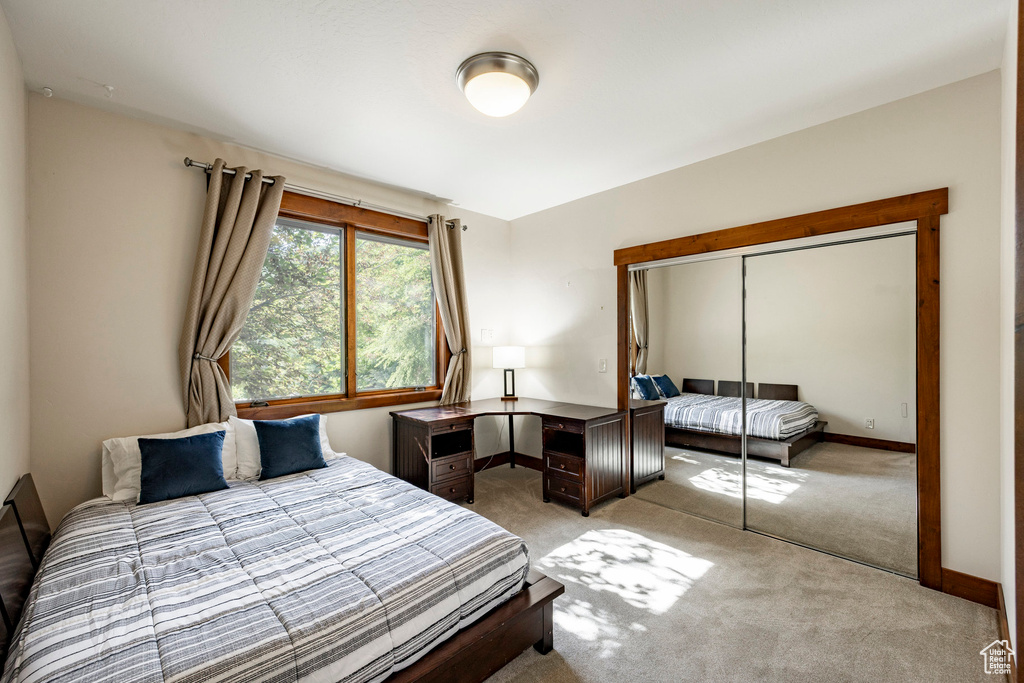 Bedroom featuring light colored carpet and a closet