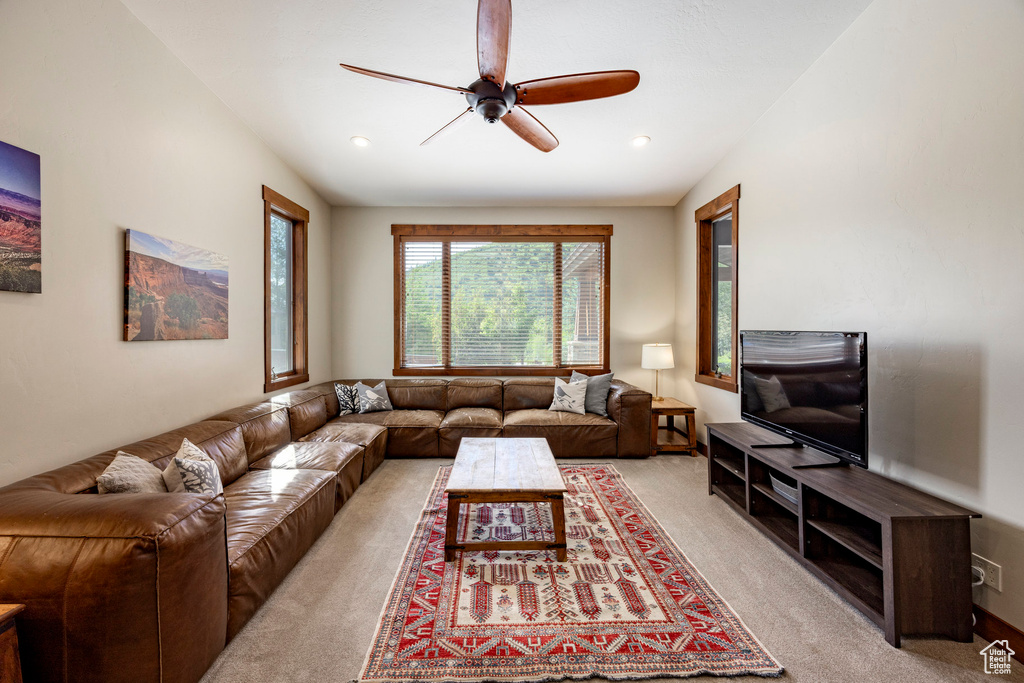 Living area featuring light carpet, ceiling fan, and recessed lighting