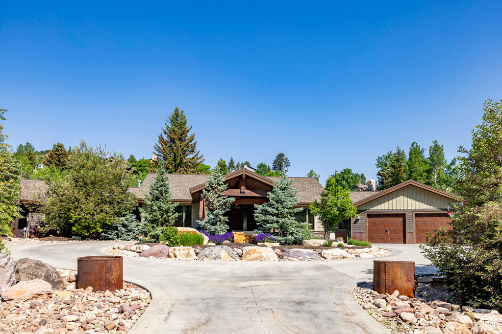 View of front of house with curved driveway and a garage