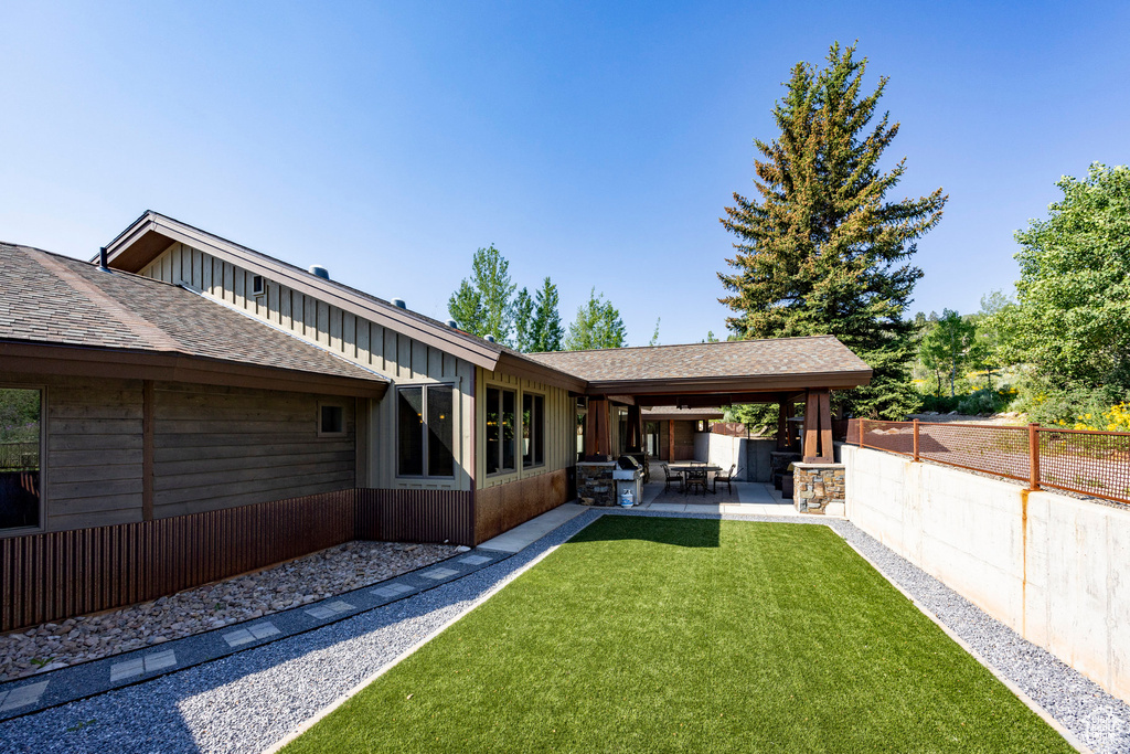 Back of property featuring a patio area and roof with shingles