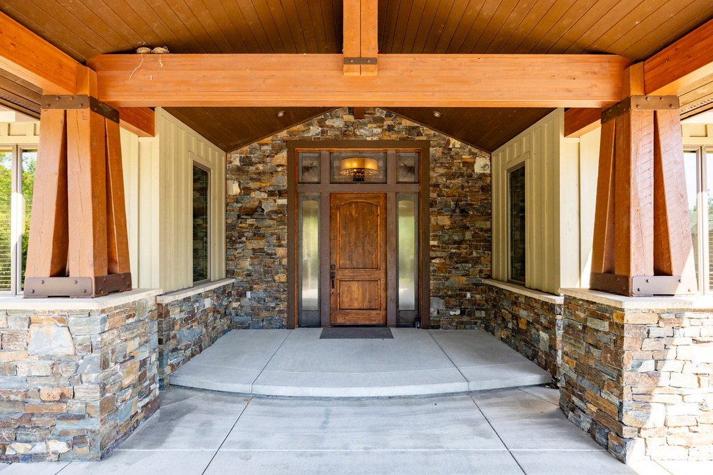 Doorway to property featuring stone siding