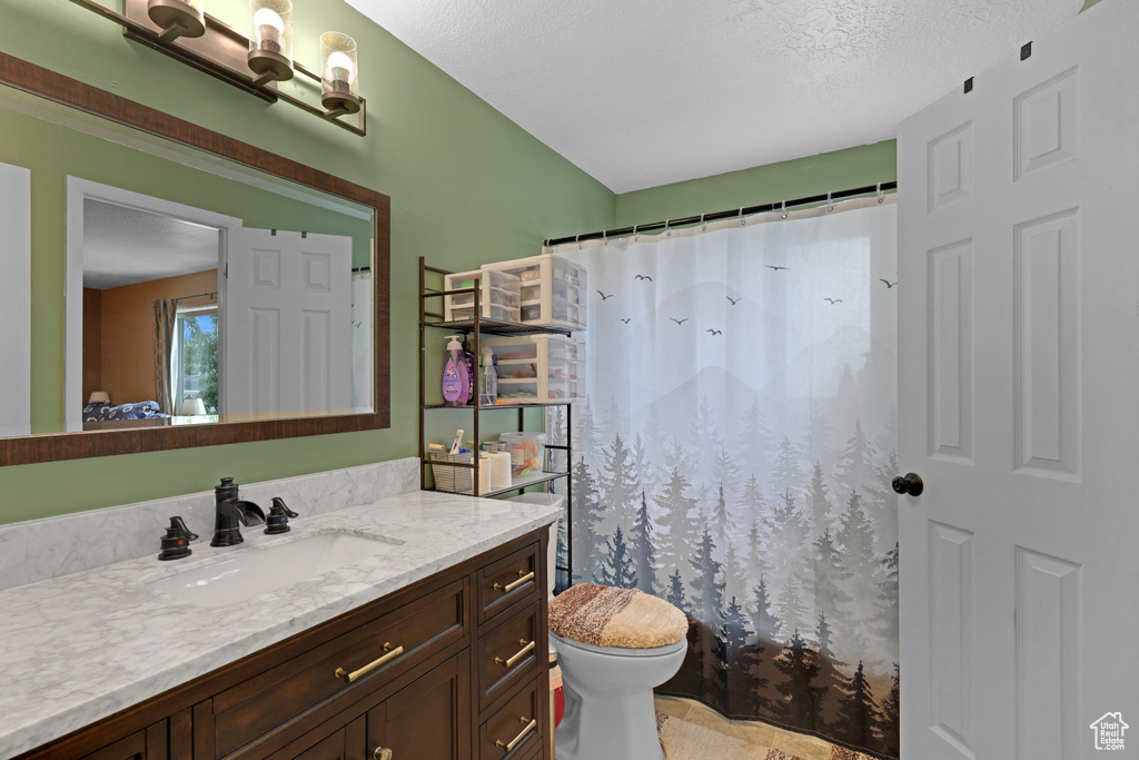 Bathroom featuring vanity, a textured ceiling, and curtained shower