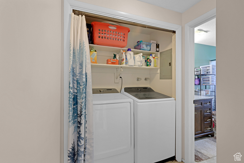 Washroom featuring electric panel and washer and dryer