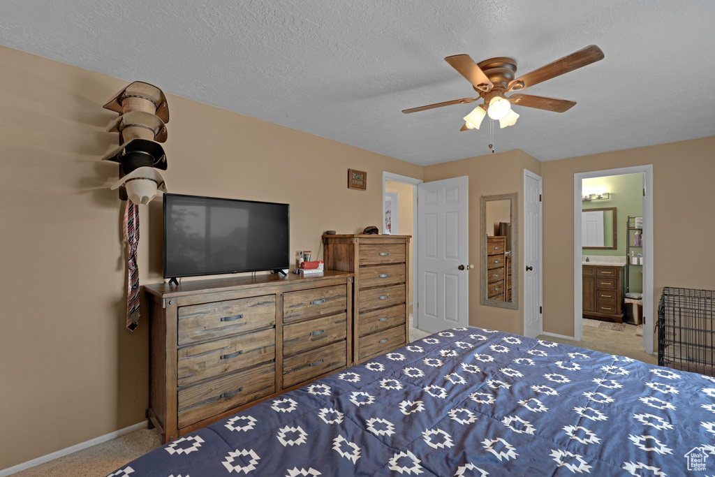 Bedroom featuring carpet, connected bathroom, ceiling fan, and a textured ceiling