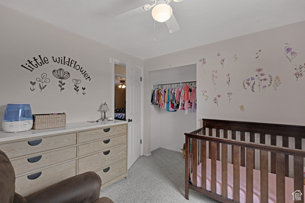 Bedroom with a nursery area and ceiling fan