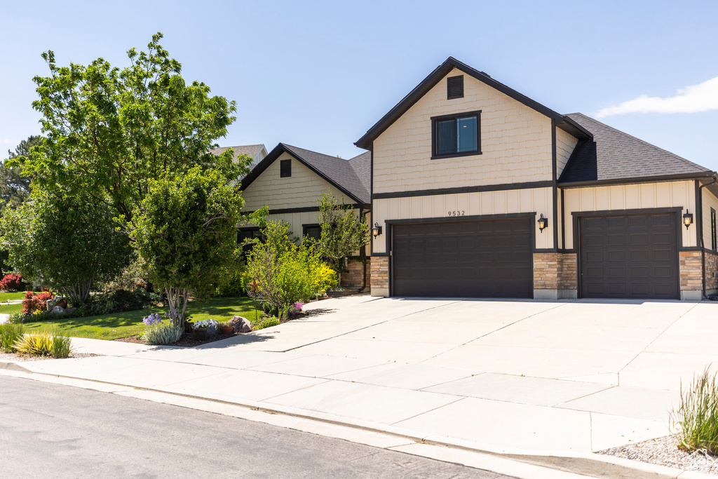 View of front facade with concrete driveway, a garage, and an attached garage