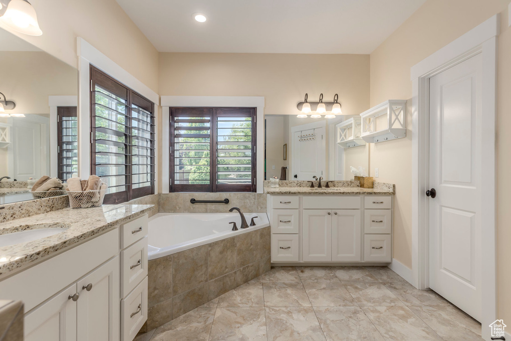 Full bathroom with two vanities and a bath