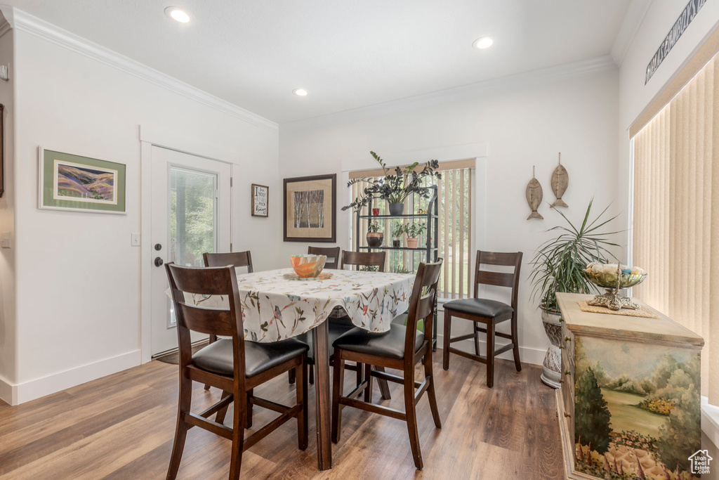 Dining area with wood finished floors, crown molding, and recessed lighting